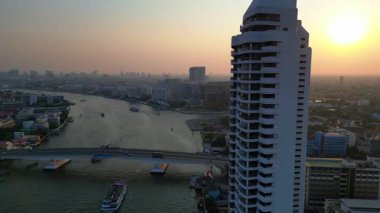 Gün batımında Chao Phraya Nehri 'nin Bangkok, Tayland' dan geçen havadan görüntüsü. Çok yakından geçen bir insansız uçak 