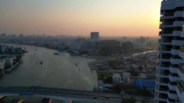 Gün batımında Chao Phraya Nehri 'nin Bangkok, Tayland' dan geçen havadan görüntüsü. Ters İHA uçuşu 