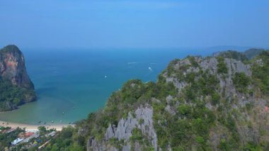 Tayland 'ın Krabi kentindeki Railay Sahili ve Phra Nang Mağara Sahili' nin hava manzarasında kireçtaşı kayalıklar, turkuaz su ve uzun kuyruklu botlar yer alıyor. hız rampası hiper hareket zaman aşımı 