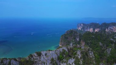 Tayland 'ın Krabi kentindeki Railay Sahili ve Phra Nang Mağara Sahili' nin hava manzarasında kireçtaşı kayalıklar, turkuaz su ve uzun kuyruklu botlar yer alıyor. panorama genel görünüm dronu 