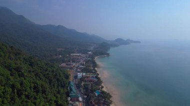 Koh Chang köyünün hava manzarası verimli tropikal ormanlar ve plaj otellerini yüzme havuzlarıyla ayırıyor. Yukarıdan insansız hava aracı görüntüleri 
