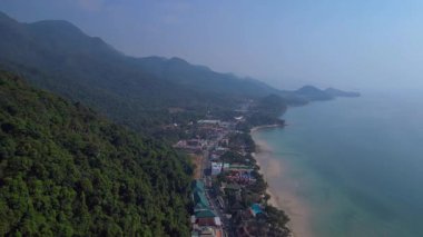 Koh Chang köyünün hava manzarası verimli tropikal ormanlar ve plaj otellerini yüzme havuzlarıyla ayırıyor. Sol İHA 'ya dön 