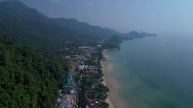 Koh Chang köyünün hava manzarası verimli tropikal ormanlar ve plaj otellerini yüzme havuzlarıyla ayırıyor. İHA alçalıyor 