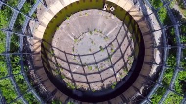 Berlin, Almanya 'da mavi bir gökyüzünün altında ağaçlar ve binalarla çevrili bir gaz sayacının hava görüntüsü. hız rampası hiper hareket zaman aşımı 