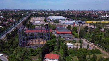 Gaz sayaçları, su kuleleri ve devam eden kentsel kalkınma projelerinin yer aldığı Berlins sanayi bölgesinin hava görüntüsü. panorama yörünge dronu 