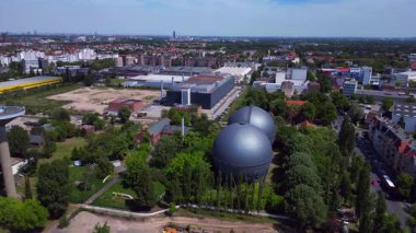 İki küresel gaz ölçer, Berlin şehir manzarasının ortasında, parlak bir yaz gününde kentsel enerji ve sanayi mirasını yakalıyor. statik üç ayaklı insansız hava aracı 