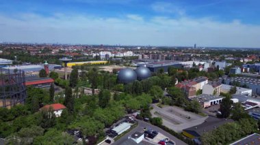 İki küresel gaz ölçer, Berlin şehir manzarasının ortasında, parlak bir yaz gününde kentsel enerji ve sanayi mirasını yakalıyor. uçuş üstü insansız hava aracı 