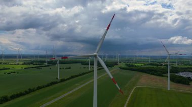 Rüzgar türbinleri Almanya 'da bulutlu bir gökyüzünün altında büyük bir rüzgar parkında temiz enerji üretiyor. hız rampası hiper hareket zaman aşımı 