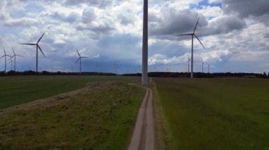 Rüzgar türbinleri Almanya 'da bulutlu bir gökyüzünün altında büyük bir rüzgar parkında temiz enerji üretiyor. hız rampası hiper hareket zaman aşımı 