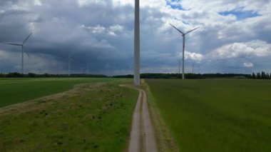 Rüzgar türbinleri Almanya 'da bulutlu bir gökyüzünün altında büyük bir rüzgar parkında temiz enerji üretiyor. hız rampası hiper hareket zaman aşımı 