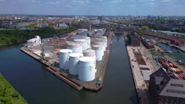 Sıvılaştırılmış doğalgaz terminali Petrokimya petrol sanayii Berlin limanındaki büyük bir sanayi limanında gaz ve petrol ürünleri için depolanan ambarlar oluşturuyor. panorama yörünge dronu 