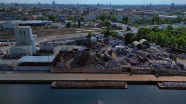 Metal bir hurdalığın havadan görünüşü, işçilerin bir şehrin yakınındaki geri dönüşüm amacıyla atık maddeleri sınıflandırdığını ve yönettiğini gösteriyor. İticileri ileri çalıştır 