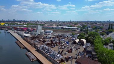 Metal bir hurdalığın havadan görünüşü, işçilerin bir şehrin yakınındaki geri dönüşüm amacıyla atık maddeleri sınıflandırdığını ve yönettiğini gösteriyor. panorama genel görünüm dronu 