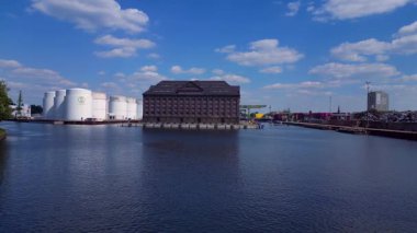 Berlin Westhafen endüstriyel limanının arka planında yakıt depolama tankları, kargo konteynerleri ve Berlin şehir manzarası var. Dolly sol İHA 