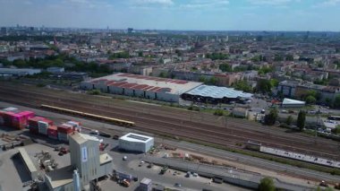 Güneşli bir günde arka planda renkli konteynırlar, trenler ve şehir manzarasının yer aldığı Berlin 'deki Westhafen sanayi limanının hava görüntüsü. Yukarıdan insansız hava aracı görüntüleri 