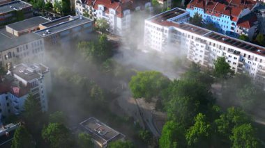 Sarı kurtarma helikopteri dumanlı bir acil durum sırasında Berlin şehir parkına iniyor. statik üç ayaklı insansız hava aracı 