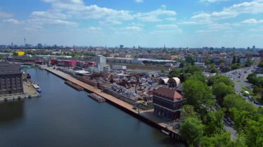 Hurda metal geri dönüşüm fabrikasının nehir limanındaki atıkları yöneten, mavnaları yükleyen hava görüntüsü. panorama genel görünüm dronu 