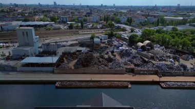 Hurda metal geri dönüşüm fabrikasının nehir limanındaki atıkları yöneten, mavnaları yükleyen hava görüntüsü. panorama genel görünüm dronu 