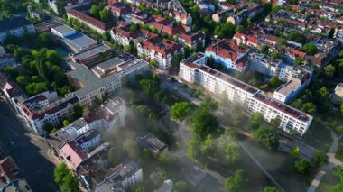 Sarı kurtarma helikopteri dumanlı bir acil durum sırasında Berlin şehir parkına iniyor. Yukarıdan insansız hava aracı görüntüleri 