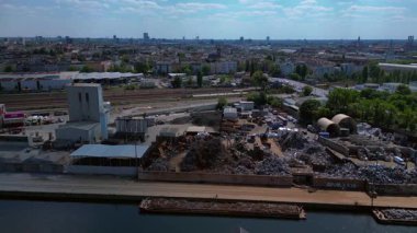 Hurda metal geri dönüşüm fabrikasının nehir limanındaki atıkları yöneten, mavnaları yükleyen hava görüntüsü. statik üç ayaklı insansız hava aracı 
