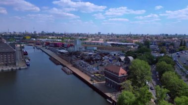 Hurda metal geri dönüşüm fabrikasının nehir limanındaki atıkları yöneten, mavnaları yükleyen hava görüntüsü. geniş yörünge görünümü dronu 