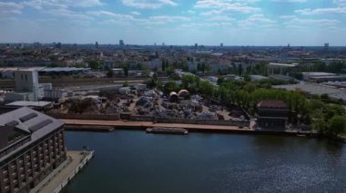 Hurda metal geri dönüşüm fabrikasının nehir limanındaki atıkları yöneten, mavnaları yükleyen hava görüntüsü. İticileri ileri çalıştır 