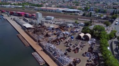 Hurda metal geri dönüşüm fabrikasının nehir limanındaki atıkları yöneten, mavnaları yükleyen hava görüntüsü. panorama genel görünüm dronu 
