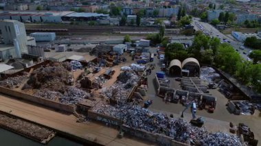 Hurda metal geri dönüşüm fabrikasının nehir limanındaki atıkları yöneten, mavnaları yükleyen hava görüntüsü. panorama genel görünüm dronu 