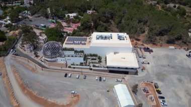 İbiza, İspanya 'da jeodezik kubbesi ve büyük bir otoparkı olan bir kulübün havadan görünüşü. Hız rampası hiper hareket zamanı hızlandırılmış panorama yörünge dronu 
