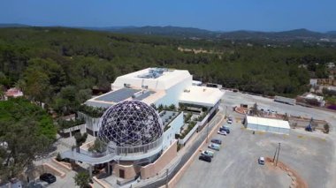 İbiza, İspanya 'da ağaçlarla çevrili, jeodezik bir kubbesi olan modern bir binanın etkileyici mimarisi yenilikçi tasarım ve rahatlık sergiliyor. panorama yörünge dronu 
