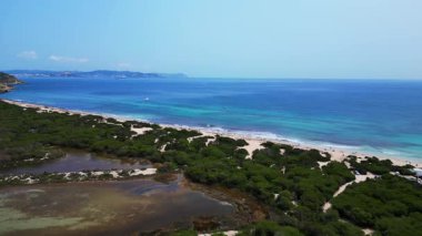 İspanya 'nın İbiza kentindeki turkuaz suları ve beyaz kumlarıyla Cavallet sahilinin çarpıcı güzelliği. panorama genel görünüm dronu 
