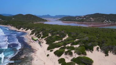 Önünde Akdeniz bitkisi olan İbiza 'nın renkli tuz düzlüklerinin havadan görünüşü. Sağ drona döndür 