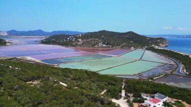 Önünde Akdeniz bitkisi olan İbiza 'nın renkli tuz düzlüklerinin havadan görünüşü. panorama yörünge dronu 
