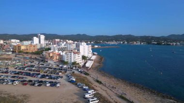 Yaz tatilinin tadını çıkaran turistler, İbiza 'nın San Antonio Körfezi' ndeki ünlü bir bar olan Kafe Mambo 'da. geniş yörünge görünümü dronu 