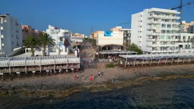 Yaz tatilinin tadını çıkaran turistler, İbiza 'nın San Antonio Körfezi' ndeki ünlü bir bar olan Kafe Mambo 'da. statik üç ayaklı insansız hava aracı 