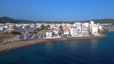 Yaz tatilinin tadını çıkaran turistler, İbiza 'nın San Antonio Körfezi' ndeki ünlü bir bar olan Kafe Mambo 'da. panorama genel görünüm dronu 