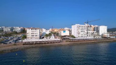 Yaz tatilinin tadını çıkaran turistler, İbiza 'nın San Antonio Körfezi' ndeki ünlü bir bar olan Kafe Mambo 'da. panorama yörünge dronu 