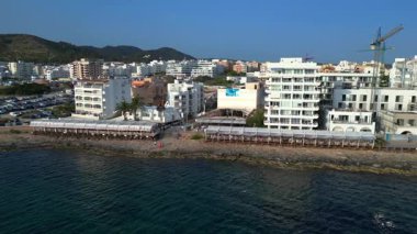 Turistler yaz tatillerini San Antonio Körfezi, İbiza 'da ünlü bir bar olan Cafe del Mar' da geçiriyorlar. Yukarıdan insansız hava aracı görüntüleri 