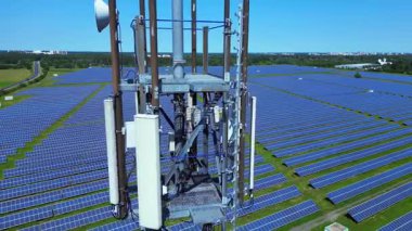 Aerial view of a telecommunication tower in a huge solar panel plant in Germany, capturing the convergence of technology and sustainability. speed ramp hyper motion time lapse fly reverse drone 