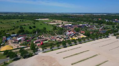 Almanya 'daki Karl Erlebnis Dorf Elstal lunaparkı hız trenleri, oyun alanları ve eğlence merkezli aile eğlenceleri sunuyor. panorama genel görünüm dronu 