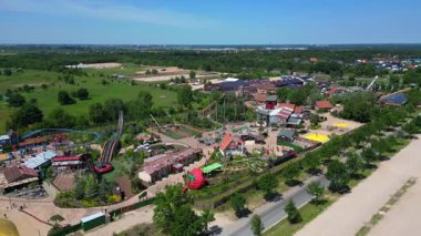 Almanya 'daki Karl Erlebnis Dorf Elstal lunaparkı hız trenleri, oyun alanları ve eğlence merkezli aile eğlenceleri sunuyor. panorama yörünge dronu 