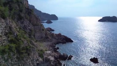 İspanya 'nın İbiza kentindeki bir körfezdeki kayaların arasından şeffaf turkuaz su akar. panorama genel görünüm dronu 