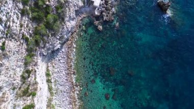 İspanya, İbiza 'nın kayalık sahillerinde kristal suyun havadan görünüşü. Yukarıdan insansız hava aracı görüntüleri 