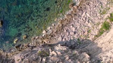 İspanya, İbiza 'nın kayalık sahillerinde kristal suyun havadan görünüşü. Yukarıdan insansız hava aracı görüntüleri 