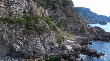 İspanya, İbiza 'nın kayalık sahillerinde kristal suyun havadan görünüşü. İHA yükseliyor 