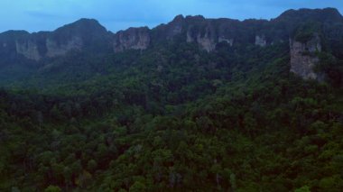 Alacakaranlıkta kireçtaşı uçurumları ve bereketli tropikal ormanlar Railay Sahili, Krabi, Tayland, dramatik ve sakin bir manzara yaratıyor. uçuş üstü insansız hava aracı 