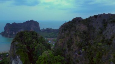 Alacakaranlıkta kireçtaşı uçurumları ve bereketli tropikal ormanlar Railay Sahili, Krabi, Tayland, dramatik ve sakin bir manzara yaratıyor. panorama genel görünüm dronu 