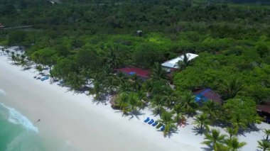 Kamboçya 'daki Koh Rong adasında, beyaz kumsaldaki tropikal bir kulübenin turkuaz suyla buluşmasının havadan görüntüsü. hız rampası hiper hareket zaman aşımı 