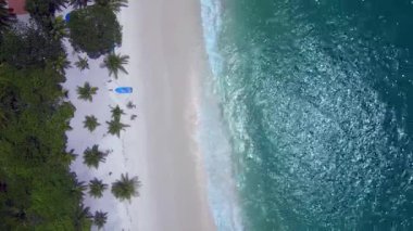 Kamboçya 'daki Koh Rong adasında, beyaz kumsaldaki tropikal bir teknenin turkuaz suyla buluşmasının hava görüntüsü. İHA kamerası aşağıya bakıyor 