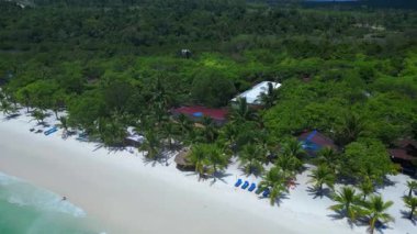 Kamboçya 'daki Koh Rong adasında, beyaz kumsaldaki tropikal bir kulübenin turkuaz suyla buluşmasının havadan görüntüsü. panorama yörünge dronu 